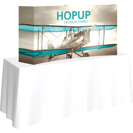 A Hopup™ 2×1 curved pop-up tabletop display set up as a 5½′ × 2½′ smooth tension fabric graphic, facing right. Perfect for advertising at meetings and retail.